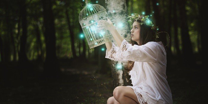 femme tenant une cage lumineuse